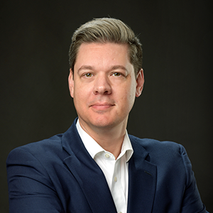 a man in a blue suit looking at the camera