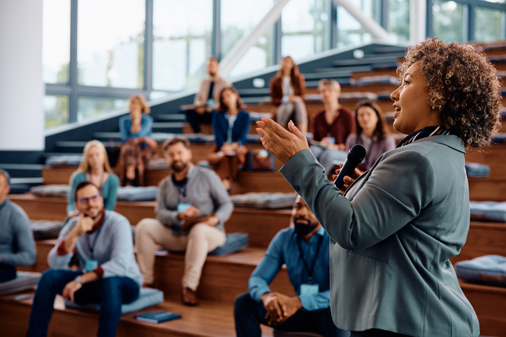 Female African American speaker talking on a business conference at convention center. stock photo