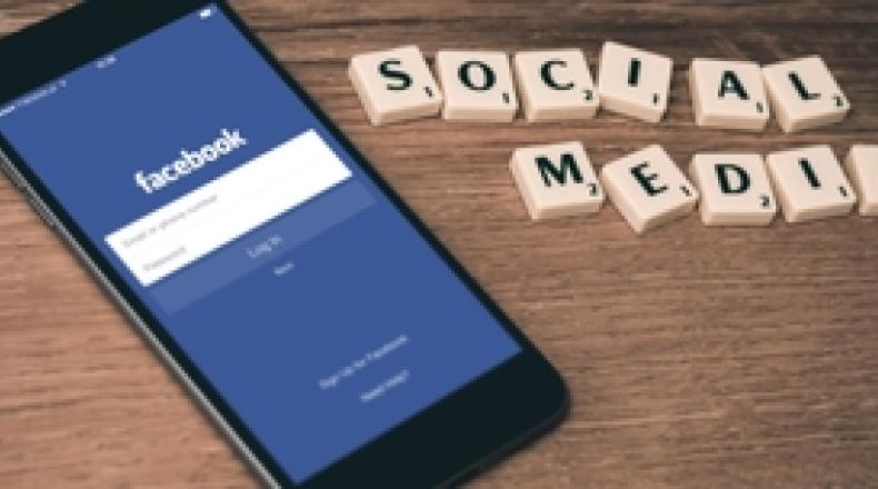 iphone showing facebook and scrabble tiles spell out social media
