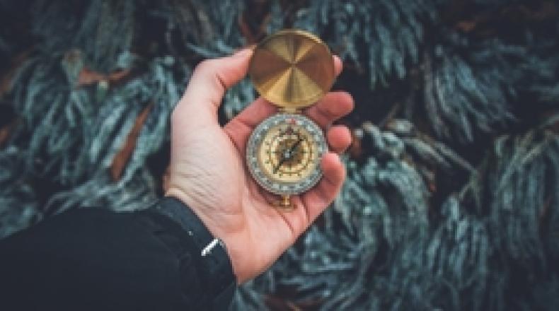 male hand holding compass