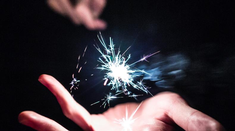 hand with sparks flying above the palm