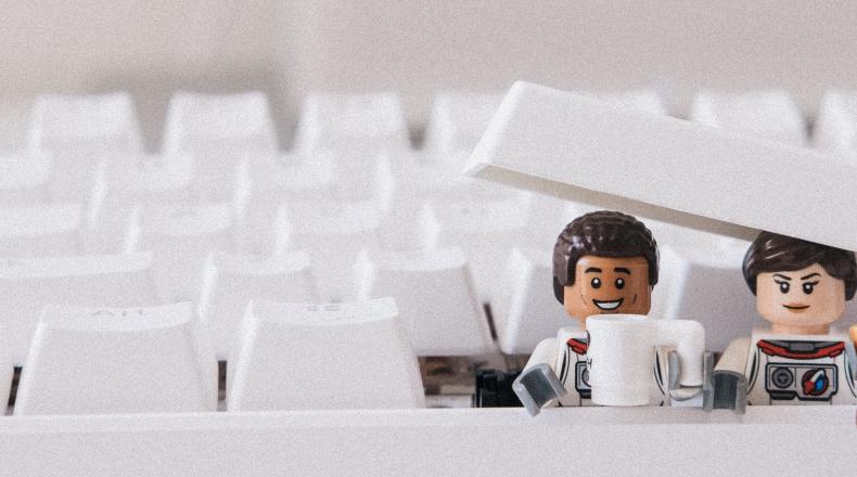 two lego people busting out of a keyboard