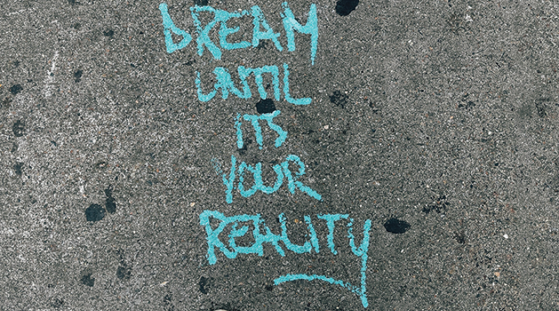 dream until its your reality written in chalk on a sidewalk