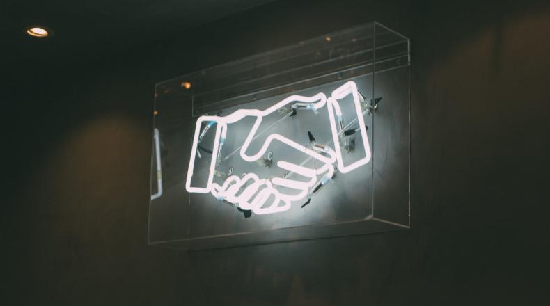 white neon sign of handshake