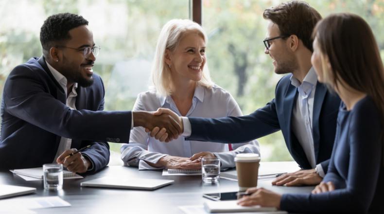 Smiling diverse employees handshake at briefing in office stock photo
