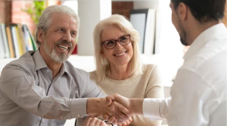 Older couple shaking hands with a man