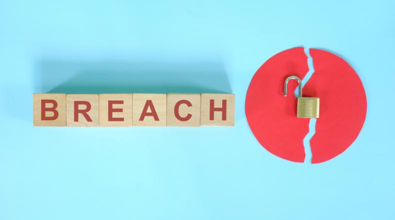 Data breach and information theft concept. Creative composition with word on wooden blocks and opened padlock.