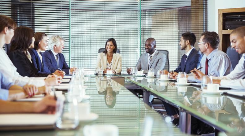 Business people having meeting in in conference room, smiling and discussing stock photo