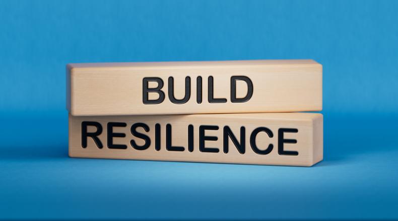 Wooden blocks with words Build resilience on blue background