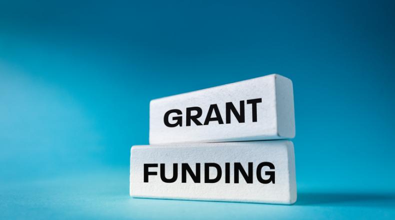 Text Grant Funding written on natural white elements on a beautiful blue background