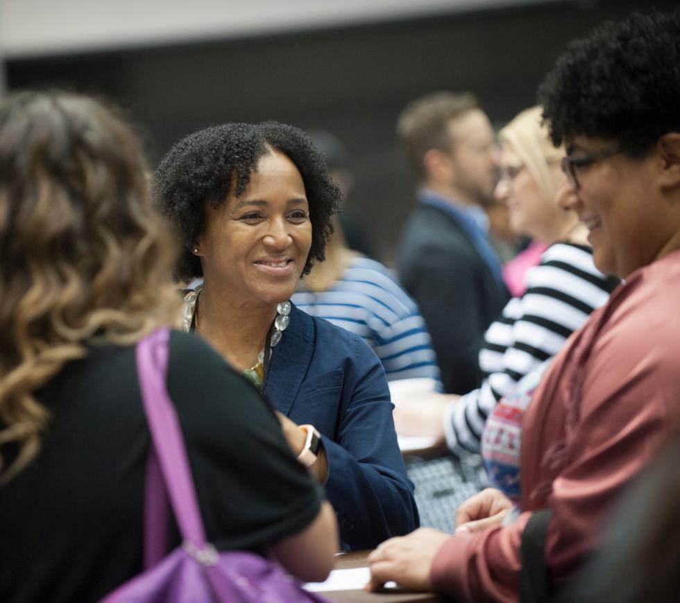Woman smiling and networking with colleagues at an AFP conference