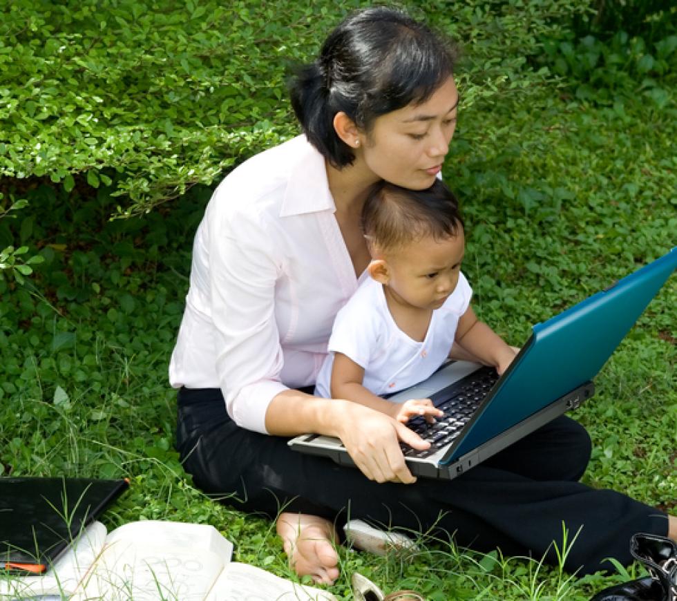 Mother and toddler playing with laptop stock photo