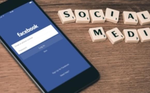 iphone showing facebook and scrabble tiles spell out social media