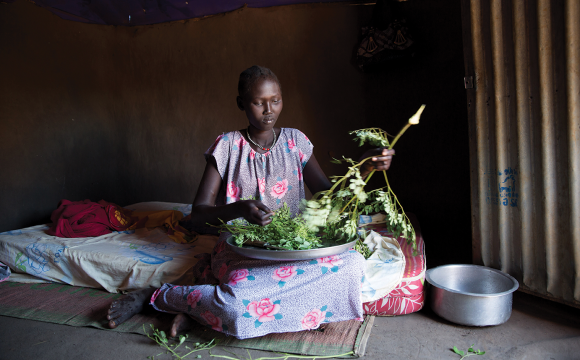 Amuor Thon Manylok prepares a meal of weed leaves for her family.