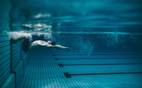 Swimmer in a pool pushing off the wall