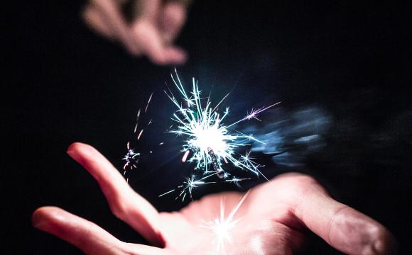 hand with sparks flying above the palm