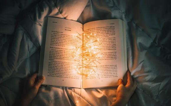 hands holding a book with lights in it