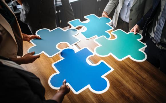 People putting a large jigsaw puzzle together