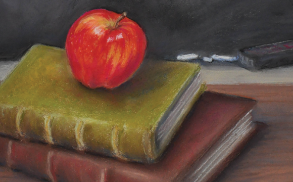 apple on a stack of books sitting on a desk in front of a chalk board