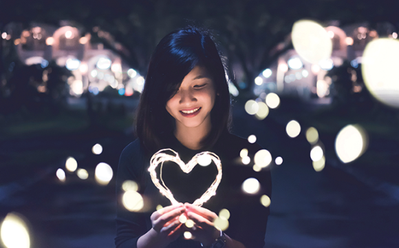 girl holding a light in the shape of a heart