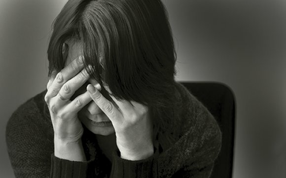 woman with depression with her head in her hands