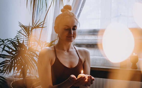 woman holding a candle meditating