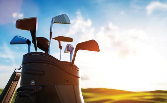 golf clubs in a bag with the sunset in the background