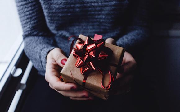 woman's hands holding a gift with a bow