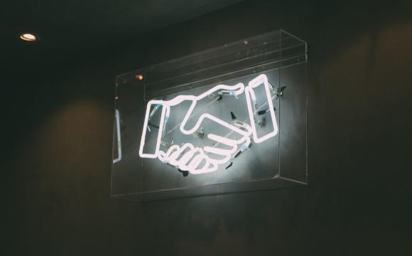 white neon sign of handshake