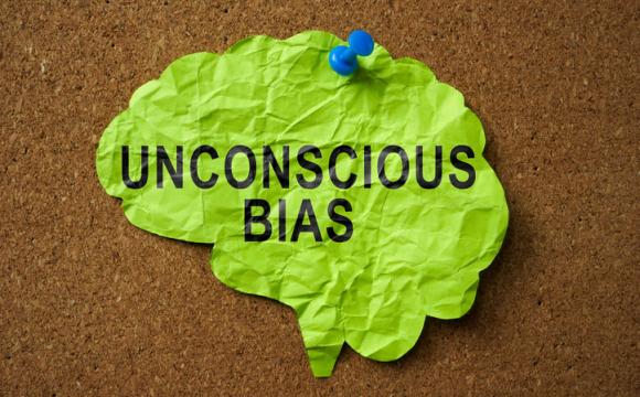 Brain made of paper with the inscription Unconscious Bias pinned to the board