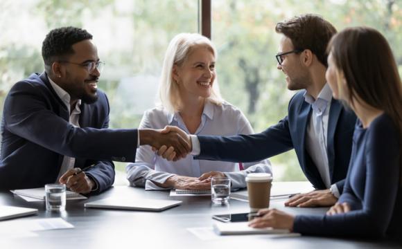 Smiling diverse employees handshake at briefing in office stock photo