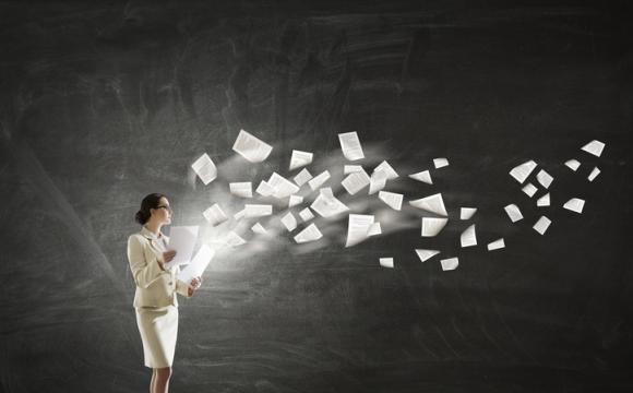 business woman in white suit with papers flying out of her hands