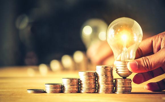 light bulb sitting on a stack of coins