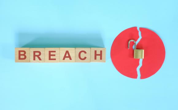Data breach and information theft concept. Creative composition with word on wooden blocks and opened padlock.