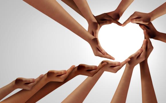 Unity And Togetherness; multi-cultural hands and arms extended to create a heart shape stock photo