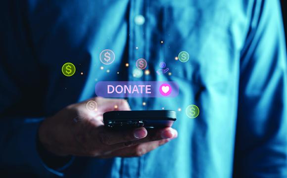 hand holding a phone with the word donate above it