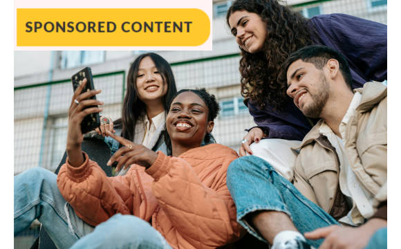 group of young multi-ethnic individuals looking at something on a cell phone; Gen Z concept